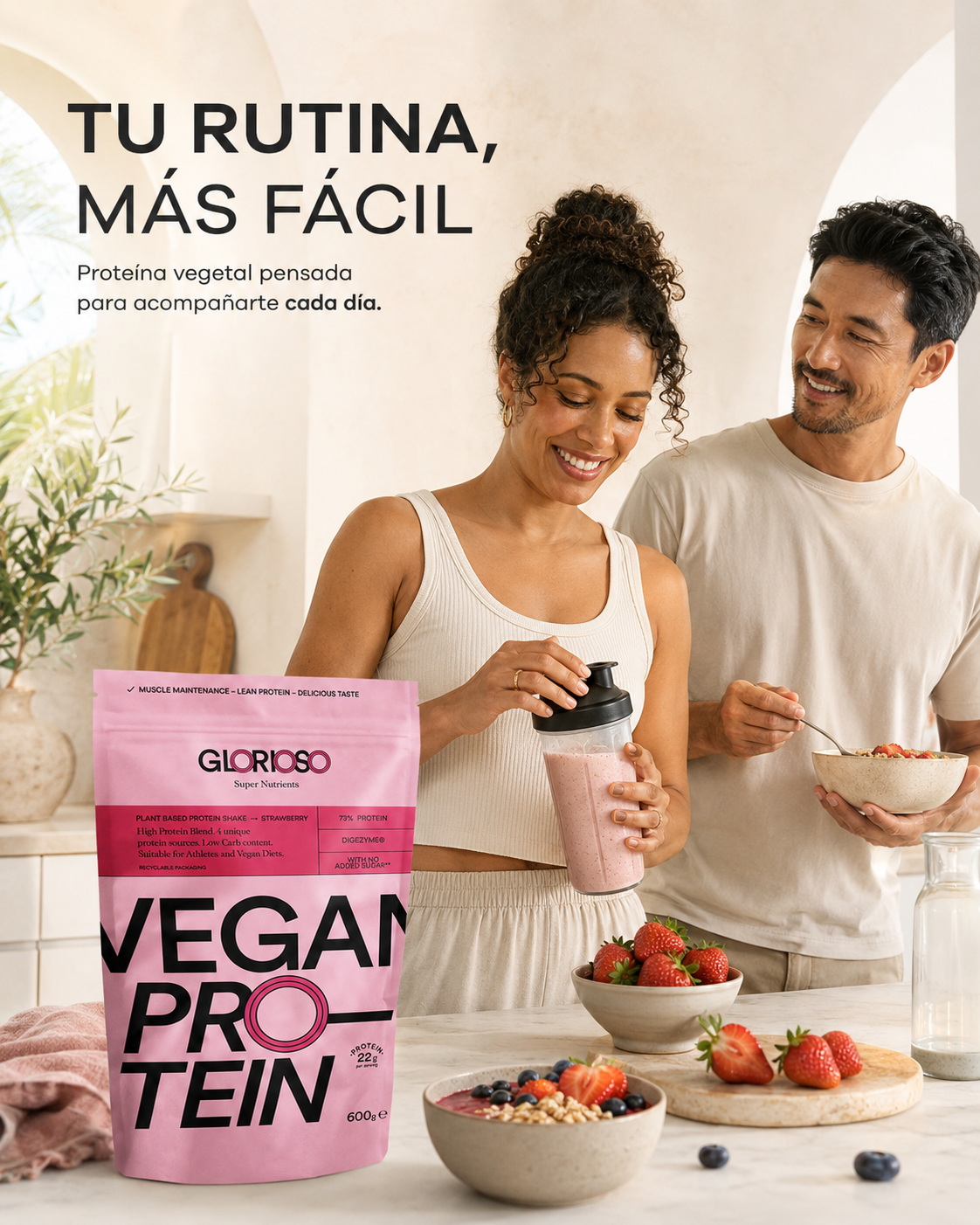 Envase de Proteína Vegana Fresa de Glorioso junto a una pareja en una cocina luminosa, con batido de fresa y desayuno saludable.