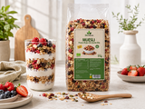 Parfait de yogur con muesli frutos rojos sin gluten bio Biosfera, fruta fresca y semillas junto a bolsa transparente del producto en cocina luminosa.